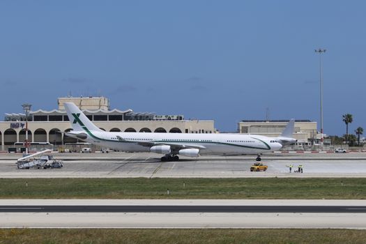 A commercial airplane parked at a terminal on a sunny day, ready for departure.