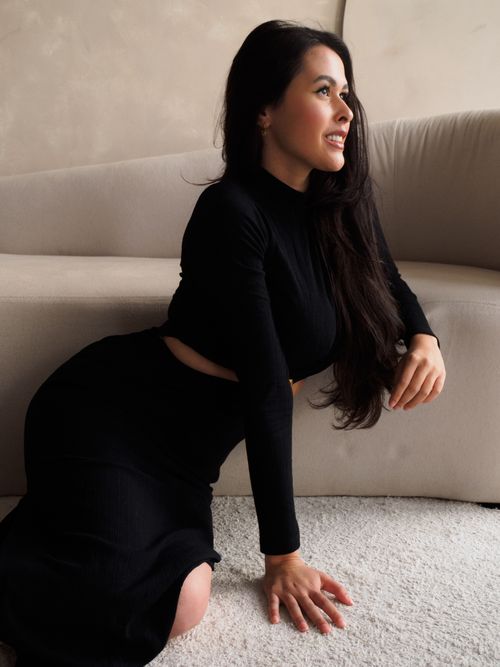 Free Stylish woman in a black outfit poses elegantly indoors on a soft carpet. Stock Photo