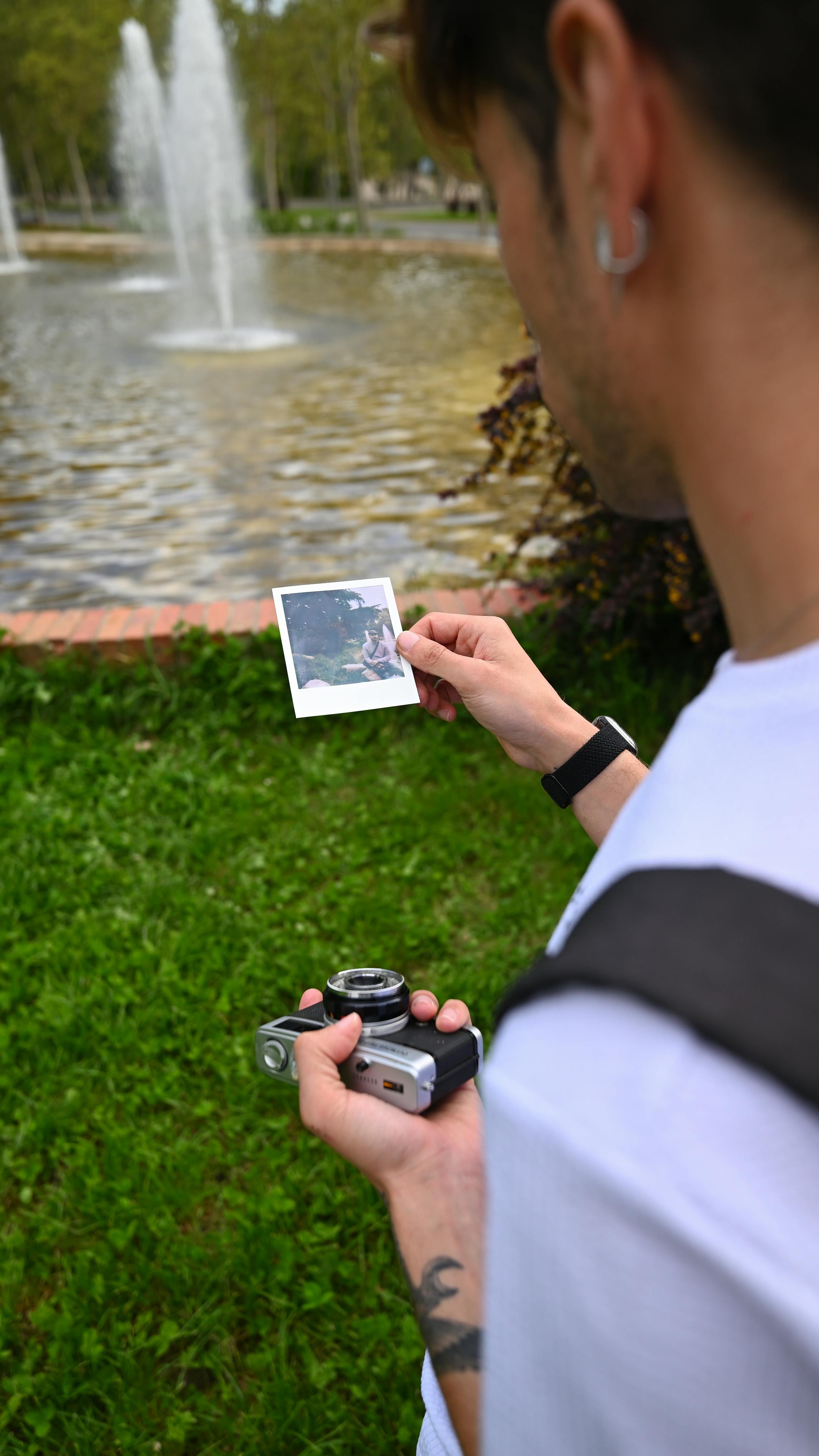 A photographer examines an instant photo in a park in Madrid.
