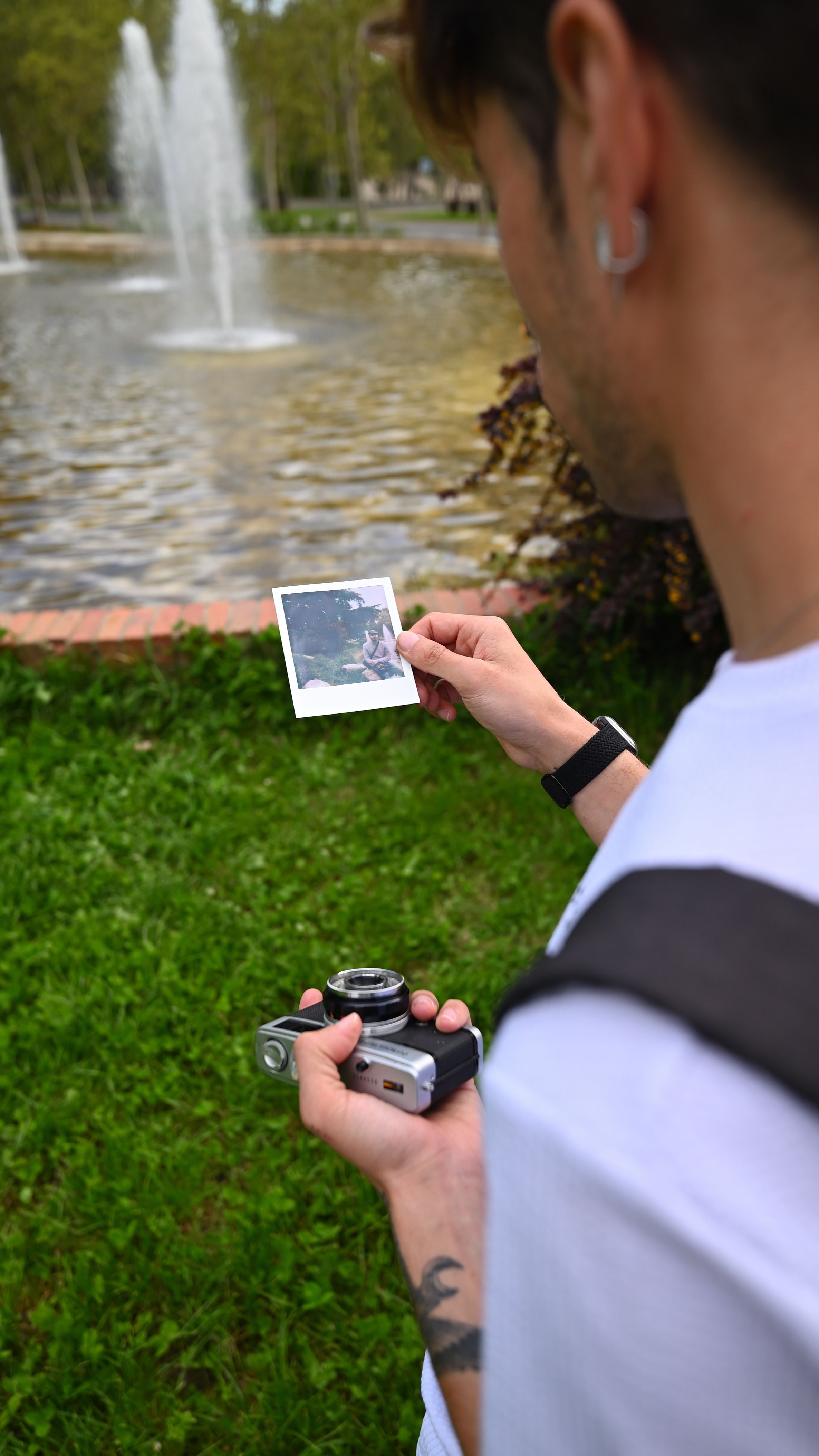De franc Un fotògraf examina una fotografia instantània en un parc de Madrid. Foto d'estoc