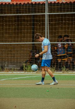 Young male athlete practicing soccer skills on a sunny day outdoor field.