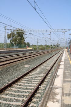 Long railway tracks under blue sky in Jerez de la Frontera, Andalucía, appearing endless.