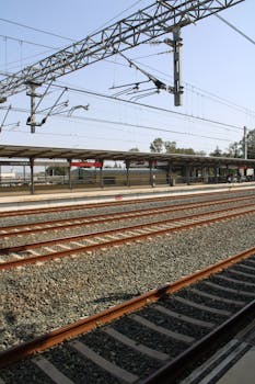 A quiet railway station in Jerez de la Frontera, Spain on a sunny day, showcasing empty tracks and platforms.