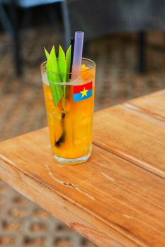 Vibrant tropical drink with green leaves and colorful straws, perfect for summer.
