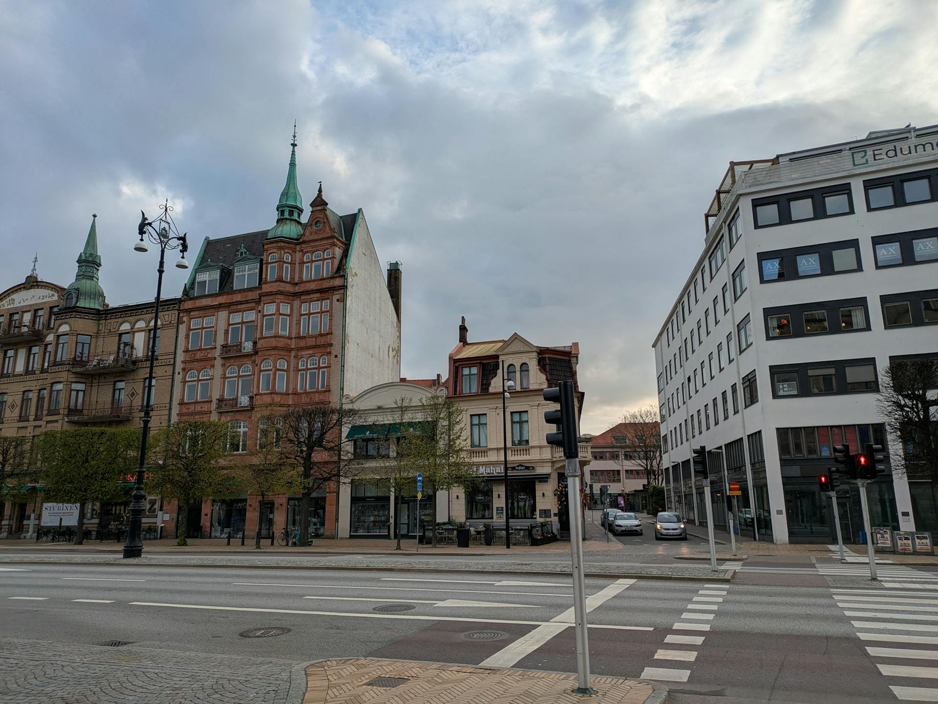 Charming street view of historic European buildings under a cloudy sky.