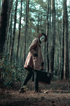 迷雾森林中，一个戴面具的人拿着公文包的怪异场景，唤起了神秘感