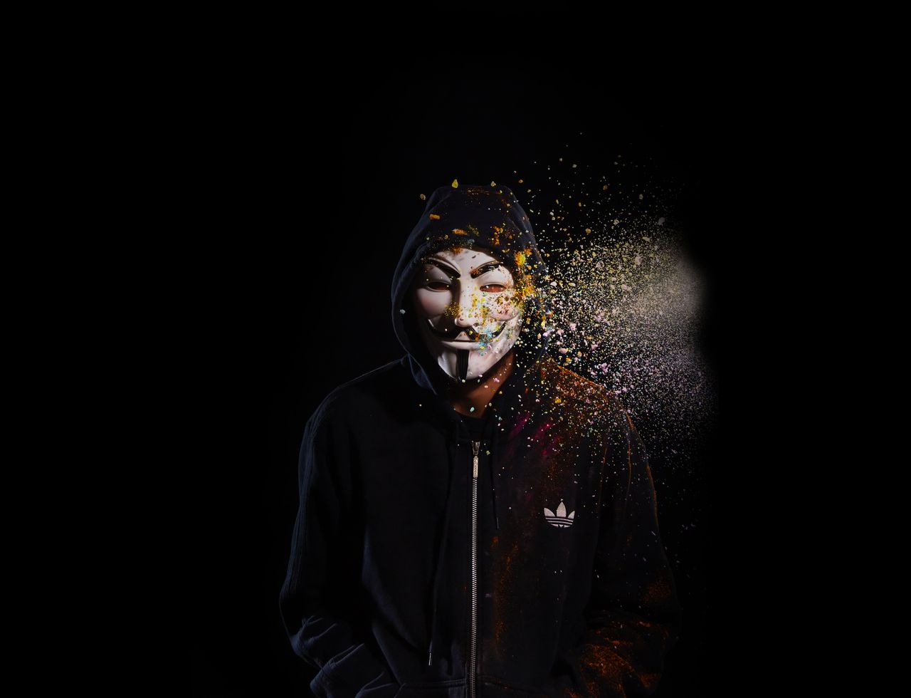 mysterious figure in a hoodie with a striking guy fawkes mask against