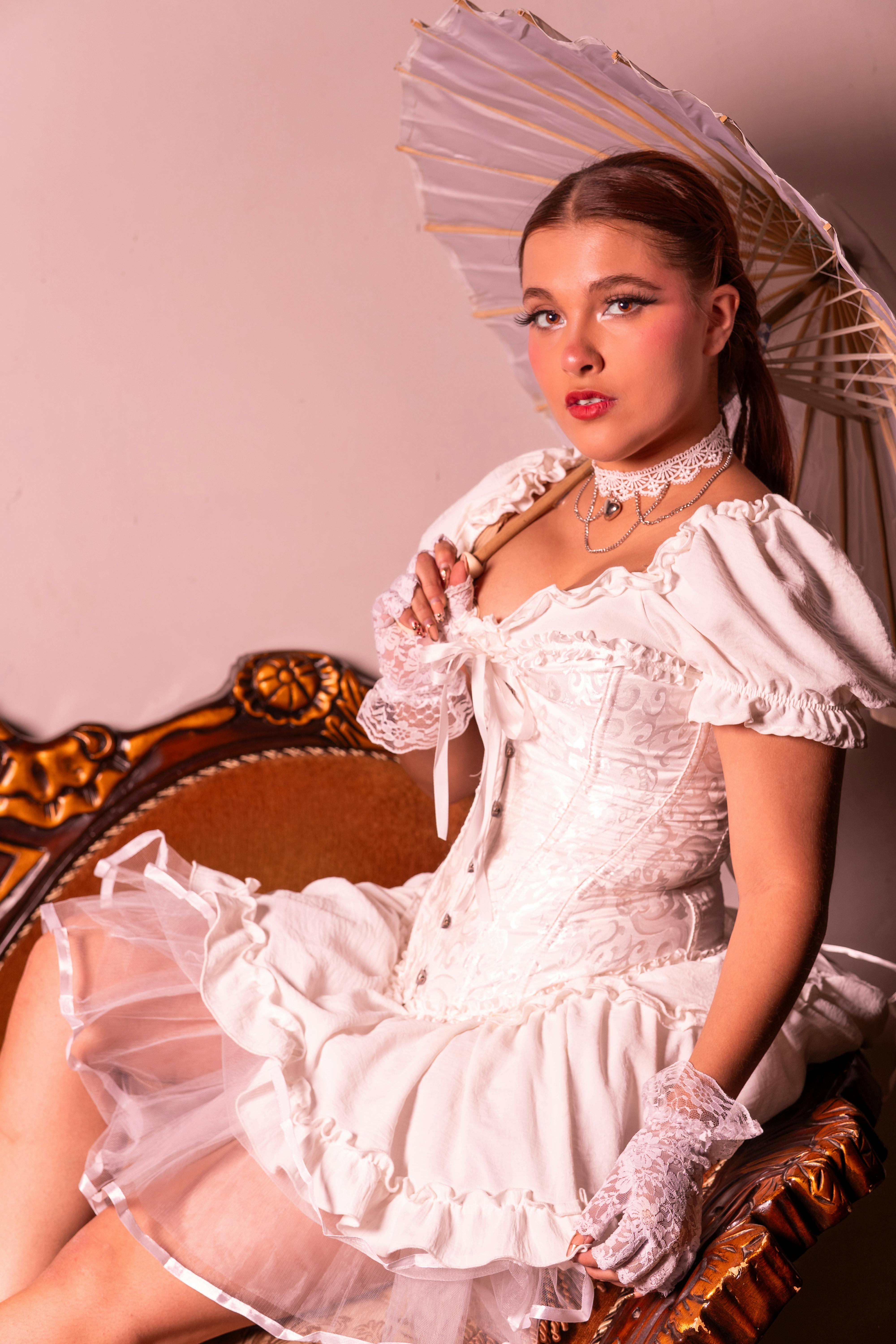 bezplatná Krásně stylizovaná hispánská modelka ve vintage bílém oblečení, zachycující klasickou eleganci. Základová fotografie