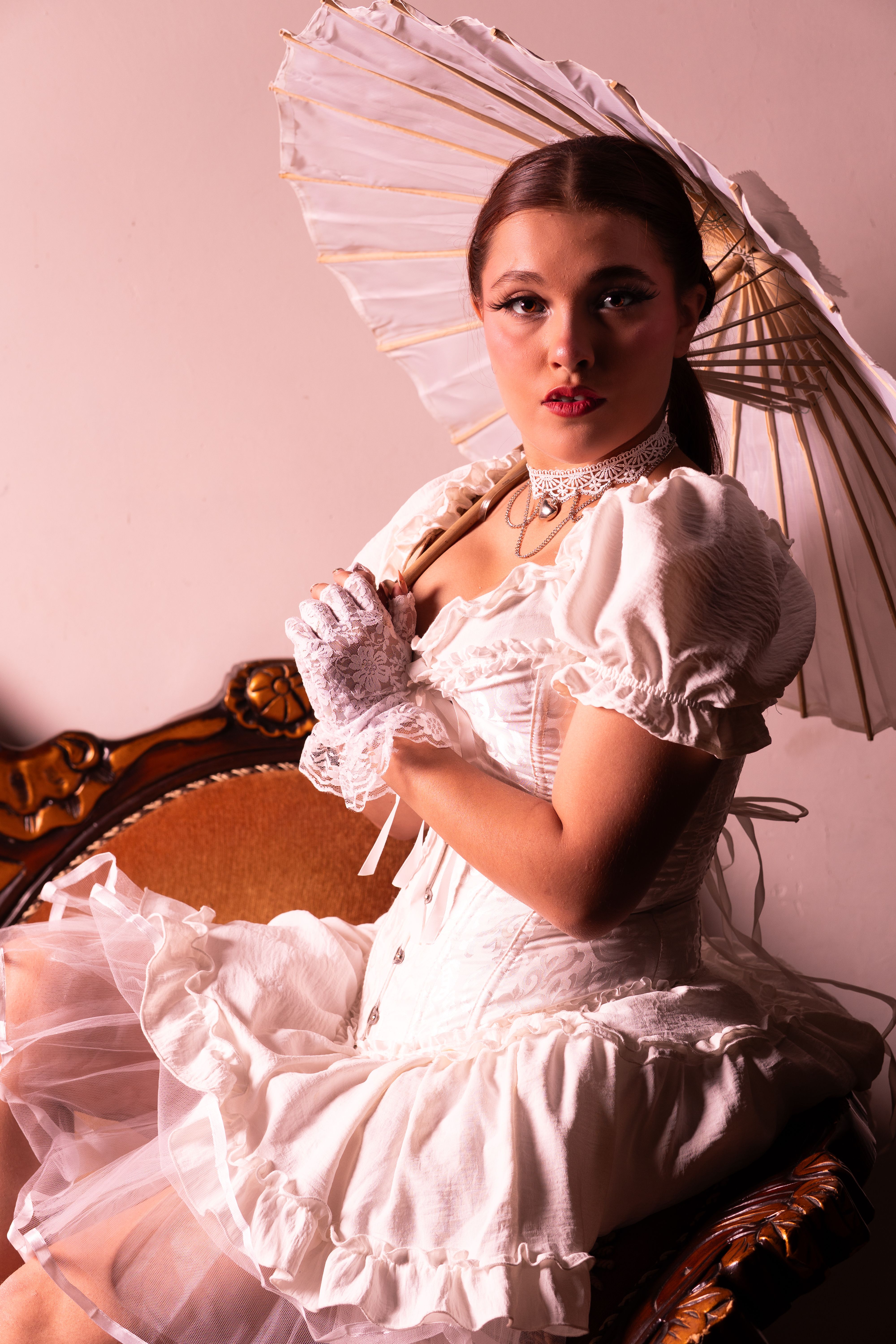 Elegant woman in vintage attire holding a parasol, exuding a classic and stylish charm.