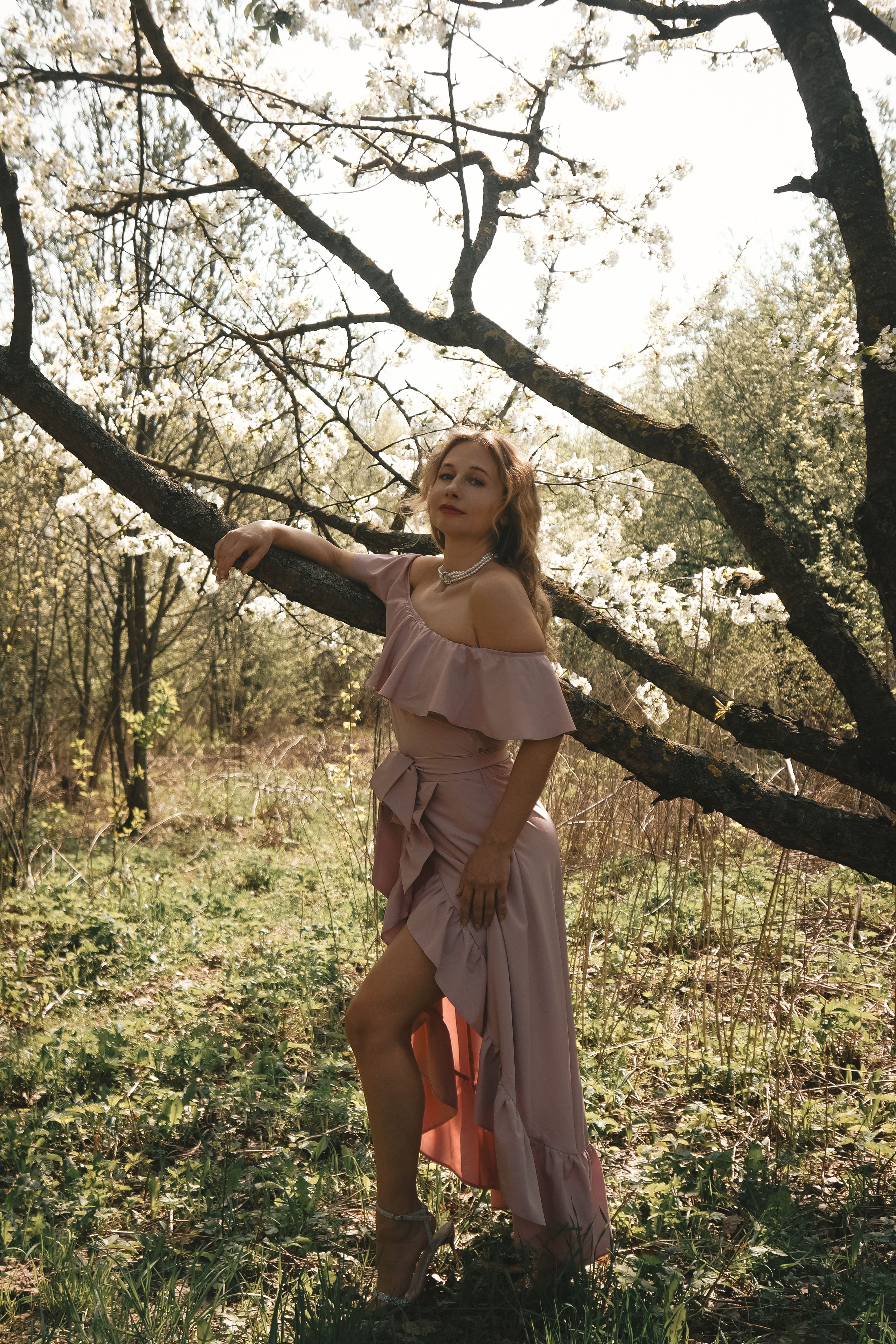 Young Woman in Floral Dress Posing Outdoors in Spring