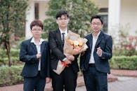 Group Photo of Well-Dressed Men Holding Bouquet Outdoors