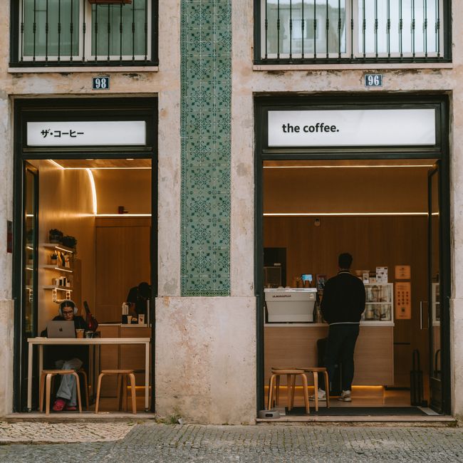 An inviting modern cafe with a minimalistic design and customers enjoying their visit.