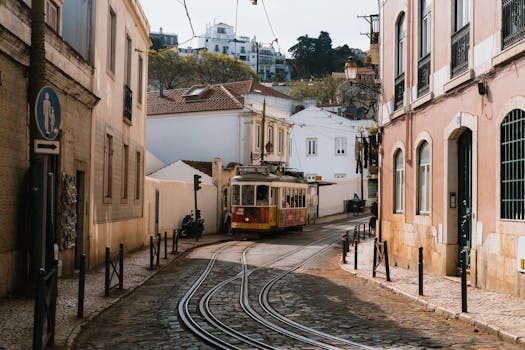 A classic tram navigating the scenic streets of Lisbon, Portugal, under a sunny day.