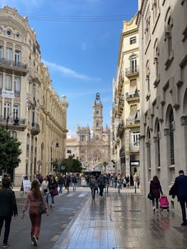 Vibrant street view with classic architecture and people strolling in a bustling European city.