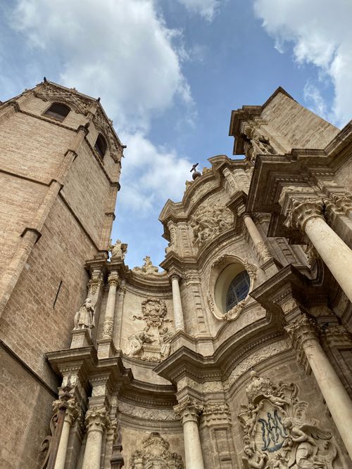 Free A stunning upward view of the Baroque facade of Valencia Cathedral under a blue sky. Stock Photo