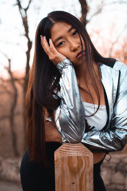 Woman Wearing Grey Jacket With Her Hand Pressed On the Side Of Her Face