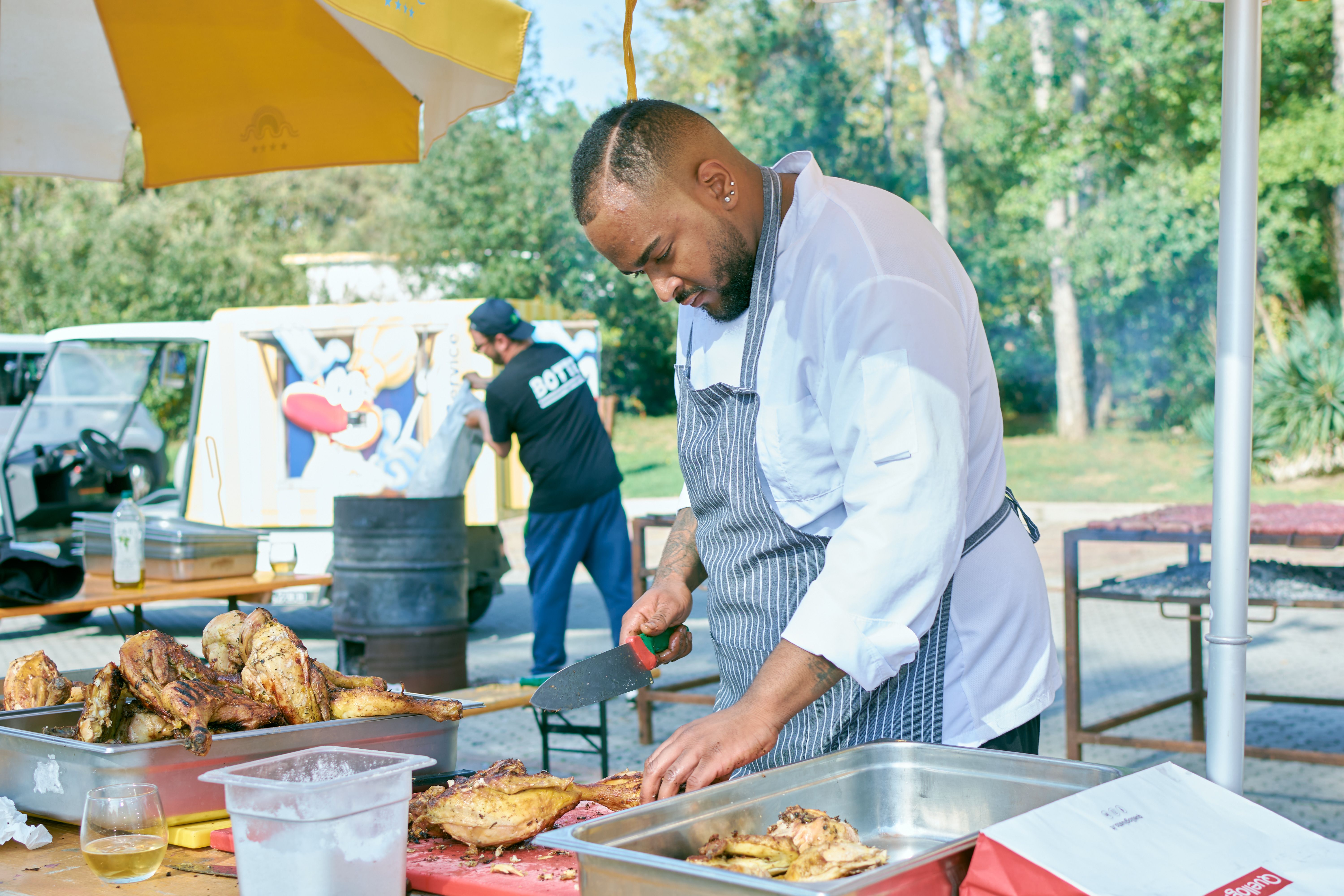 Chef preparing grilled chicken at outdoor event · Free Stock Photo