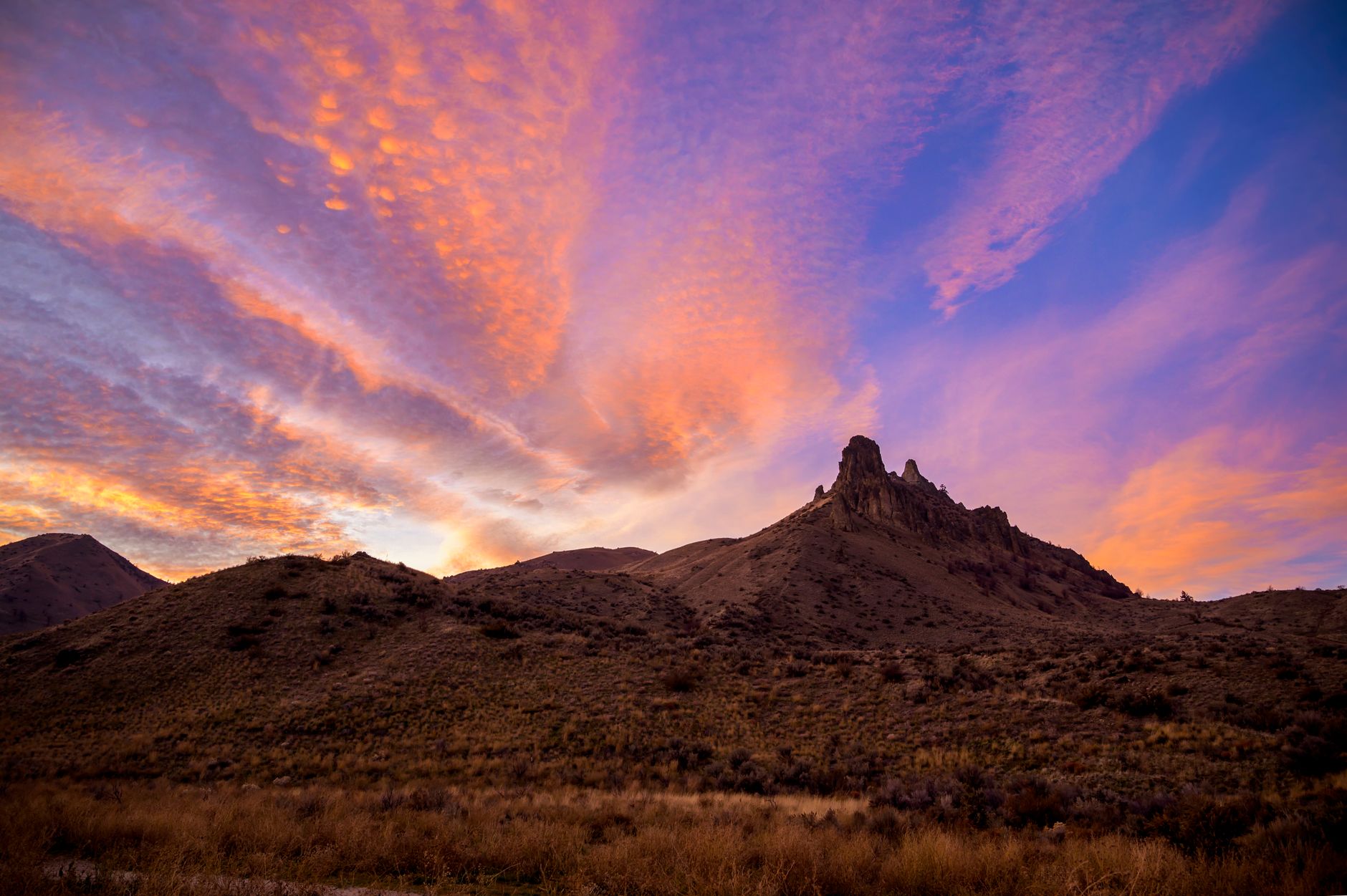 Breathtaking view of a vibrant sunset over rugged mountains in Wenatchee, Washington.