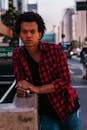 一名时尚男子身穿红色格子衬衫，在圣保罗繁华的街道上摆姿势