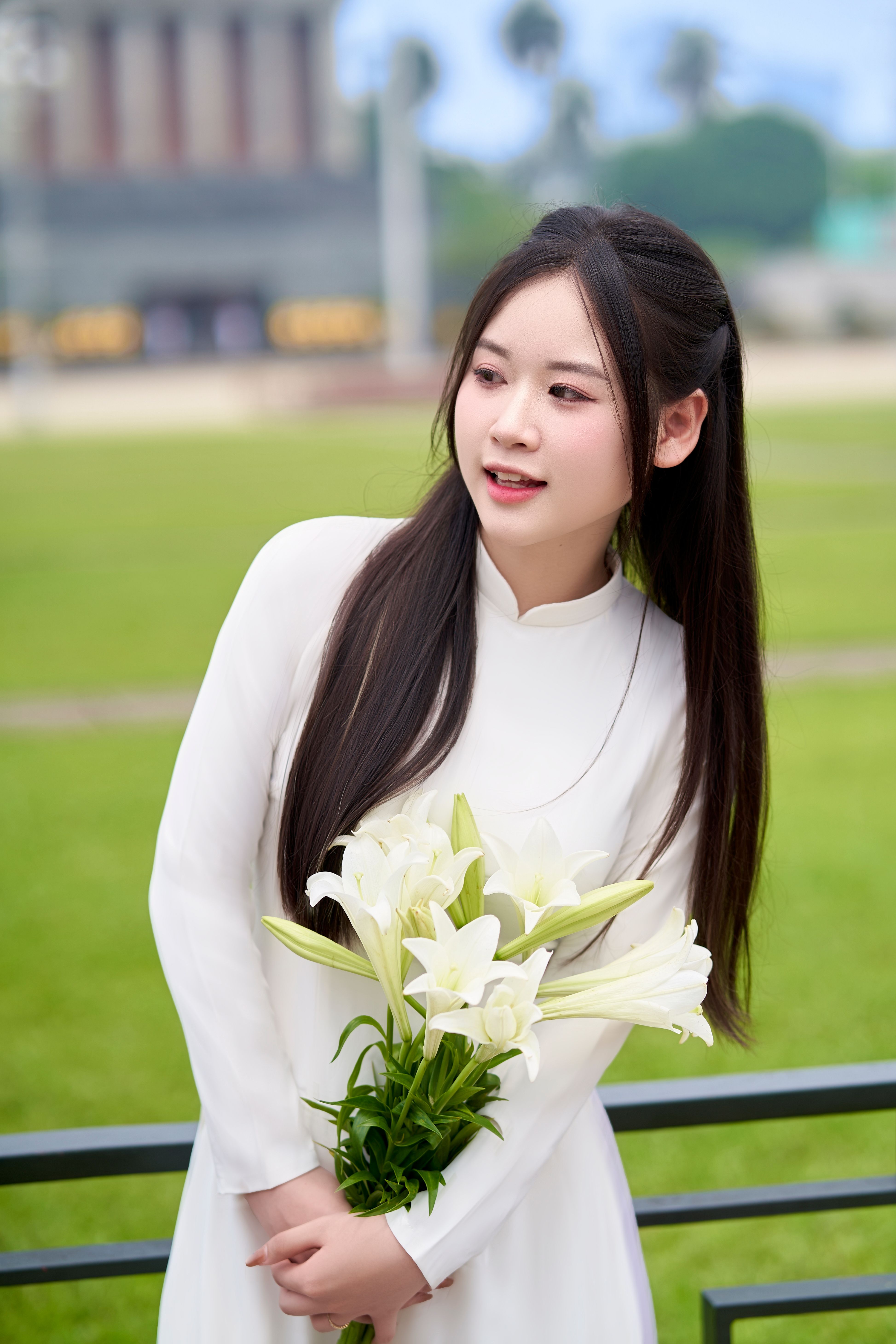 Young Woman Holding White Lilies Outdoors · Free Stock Photo