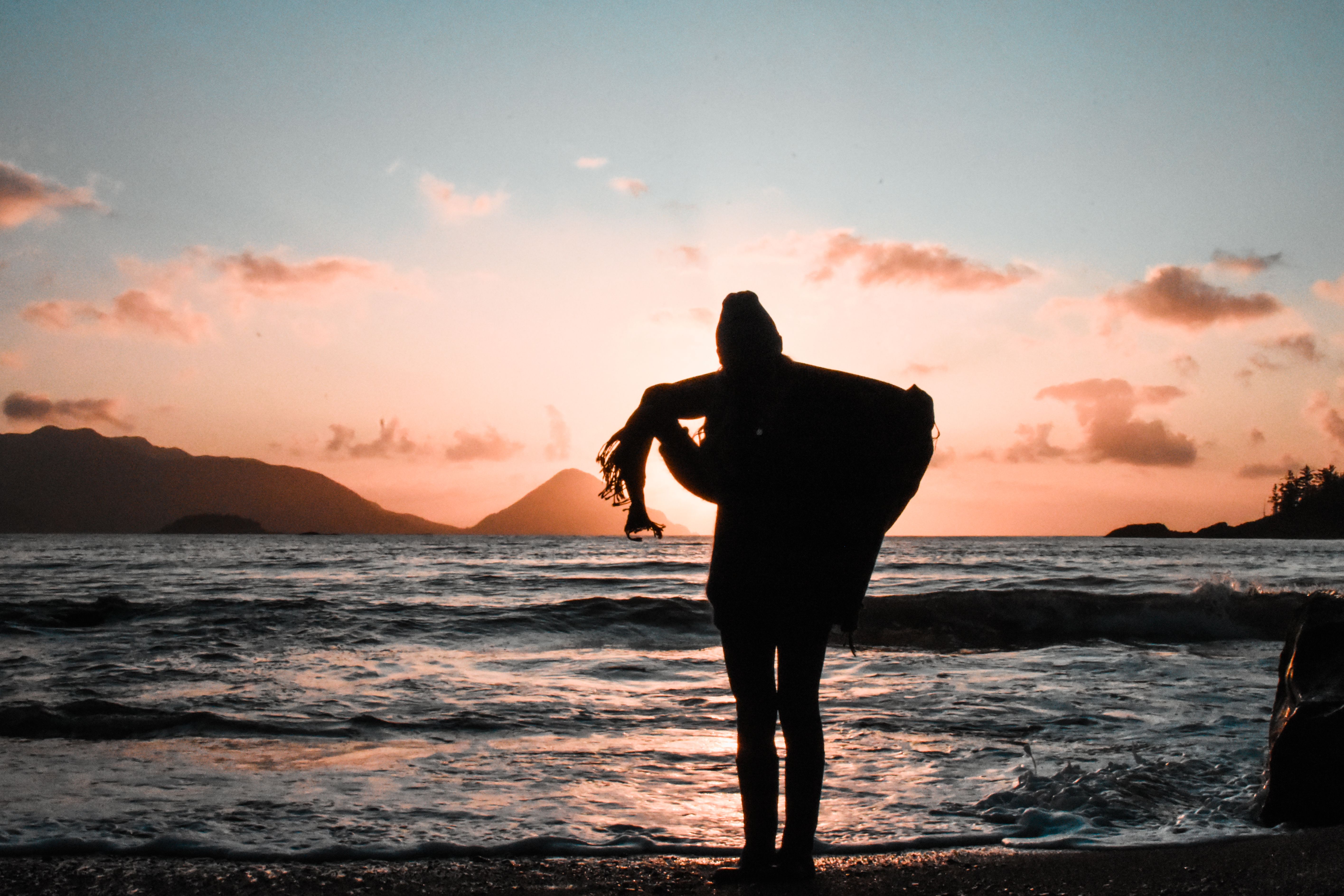 Silhouette of Woman Standing on the Seashore · Free Stock Photo