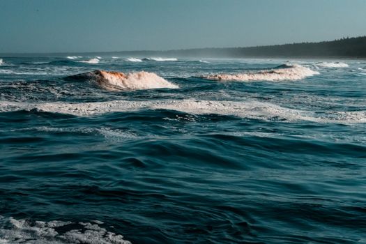 Tranquil ocean waves creating a peaceful seascape under a clear, bright sky.