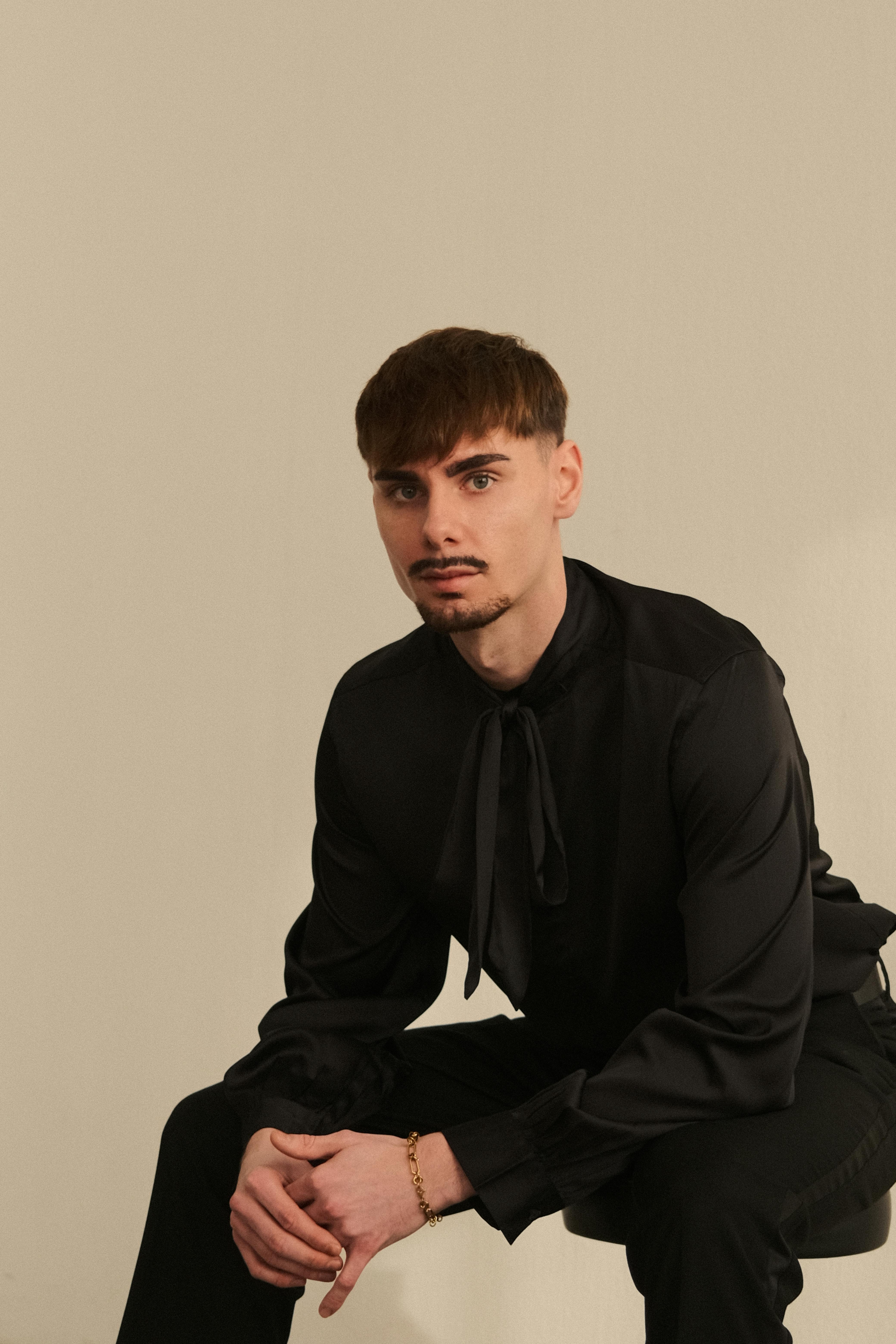 Ilmainen Tyylikäs mies mustassa asussa poseeraa sisällä ja esittelee modernia tyyliä. Kuvapankkikuva