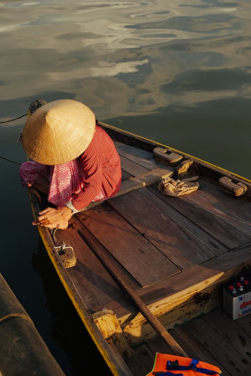 Person Sitting on Brown Wooden Boat