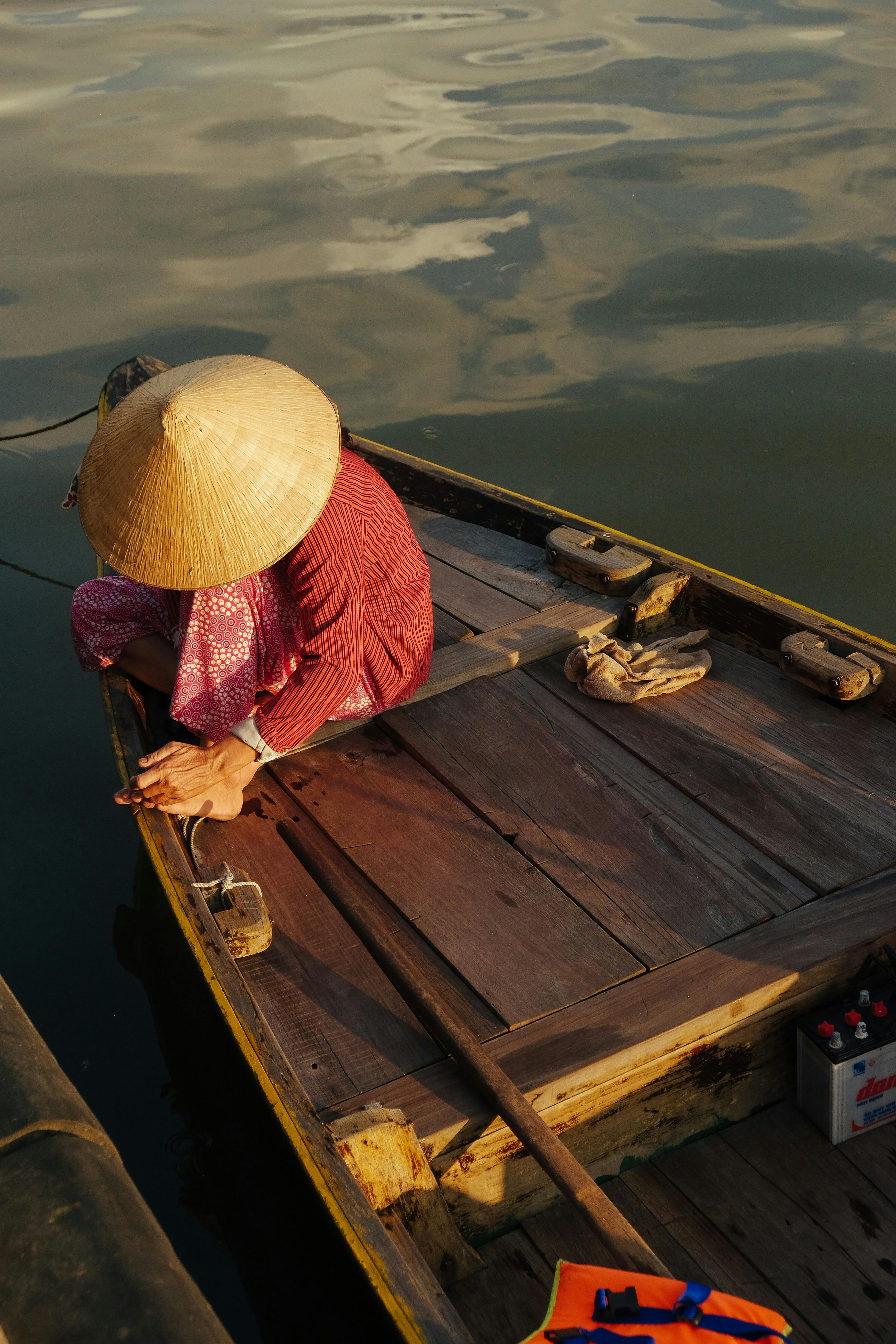 Person Sitting on Brown Wooden Boat · Free Stock Photo