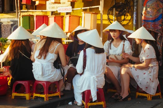阳光明媚的日子里，戴着传统圆锥帽的女性们聚集在户外，享受休闲时光
