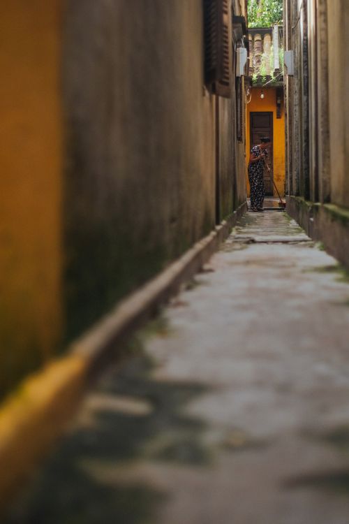 Free A narrow urban alley with a focused perspective highlighting architectural elements. Stock Photo