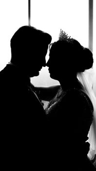 Silhouette of a loving bride and groom embracing on their wedding day.