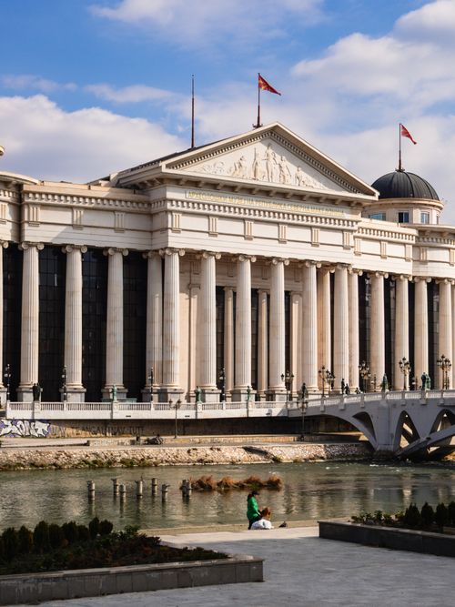 Free A view of the neoclassical building by the river with flags waving, in Skopje, Macedonia. Stock Photo