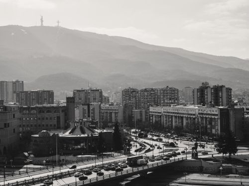 Free Aerial view of Skopje cityscape with distant mountains and urban architecture. Stock Photo