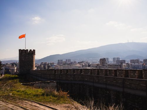 Free Panoramic view from Skopje Fortress with cityscape and Macedonian flag under clear blue sky. Stock Photo