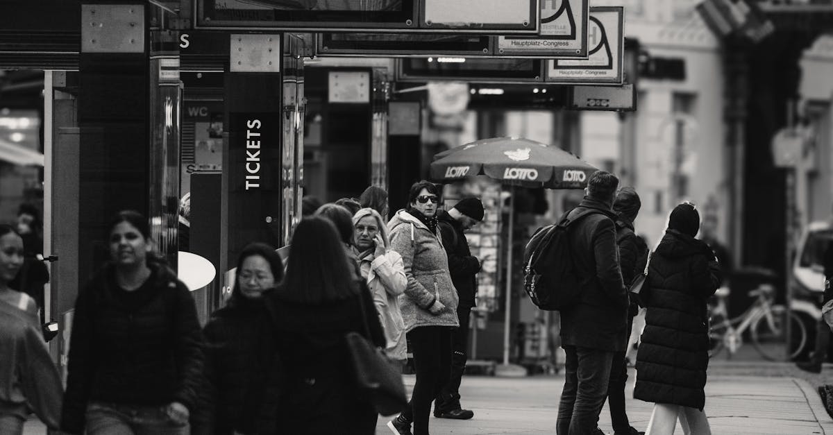 Black and white photo capturing a bustling street scene in Graz, Austria, with people waiting and walking.