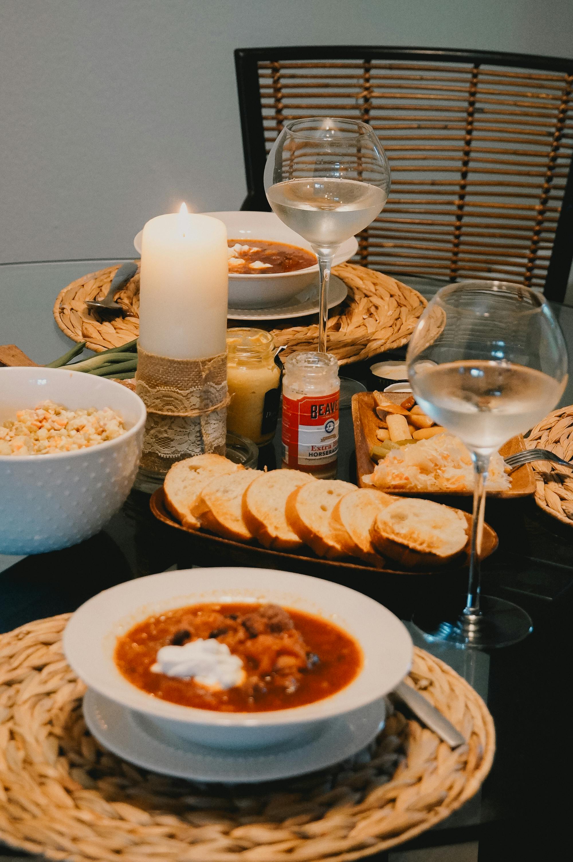 Gratuit Arrangement de table de dîner invitant comprenant de la soupe, du vin et des bougies pour une expérience culinaire chaleureuse. Photos