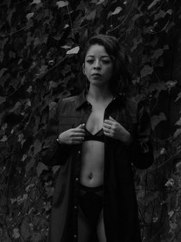 Sensual black and white portrait of a woman in nature, evoking mystery and elegance.