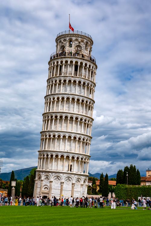 Free The famous Leaning Tower of Pisa surrounded by tourists on a cloudy Italian day. Stock Photo