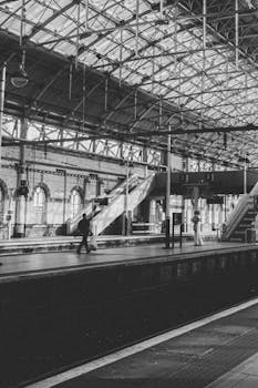 Classic black and white photo capturing a quiet moment in an urban English train station.
