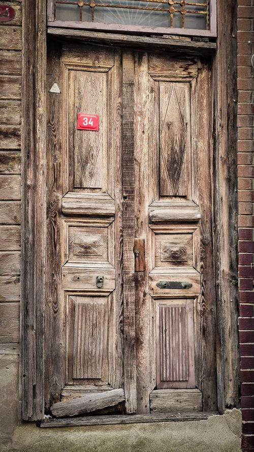 Free Rustic wooden door with number 34, showcasing vintage charm and aged texture. Stock Photo