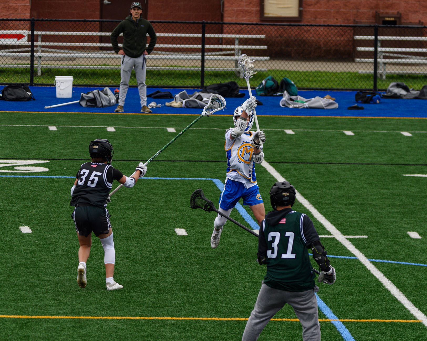 Young athletes in a thrilling lacrosse match on a vibrant green field.