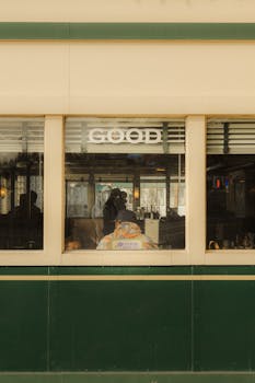 View through a vintage diner window showcasing a classic retro ambiance with customers inside.