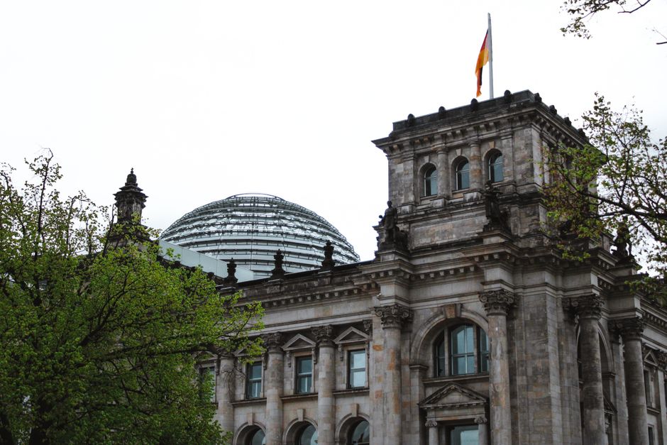 Fotomural Vista del histórico edificio del Reichstag en Berlín con su icónica cúpula de cristal y bandera alemana.