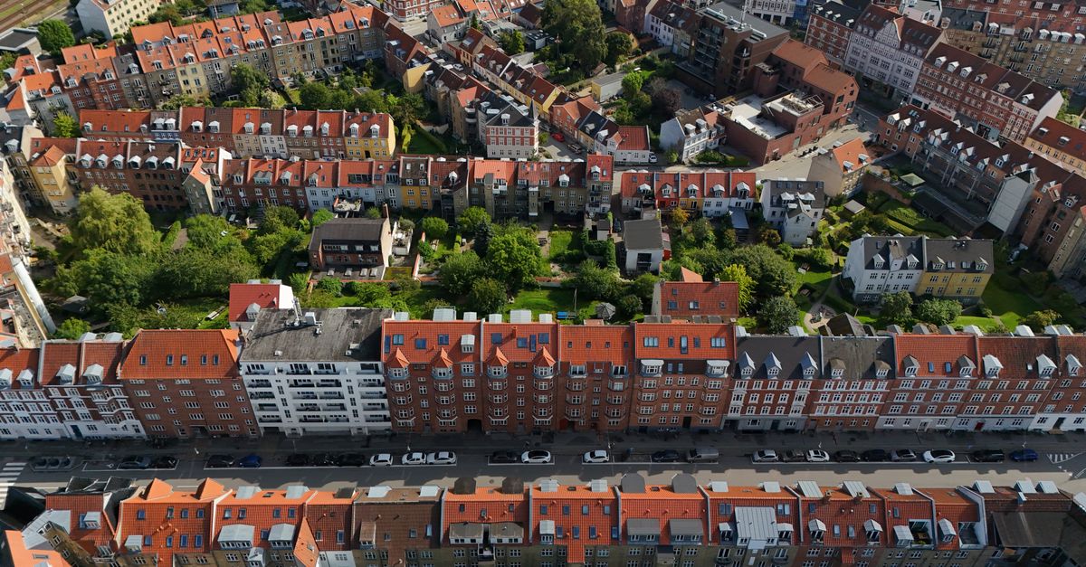 Aerial shot of Aarhus, Denmark showcasing residential architecture with red rooftops and greenery.