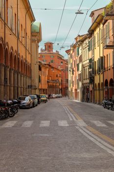 A picturesque street in Bologna, Italy, showcasing historic architecture and vibrant colors.