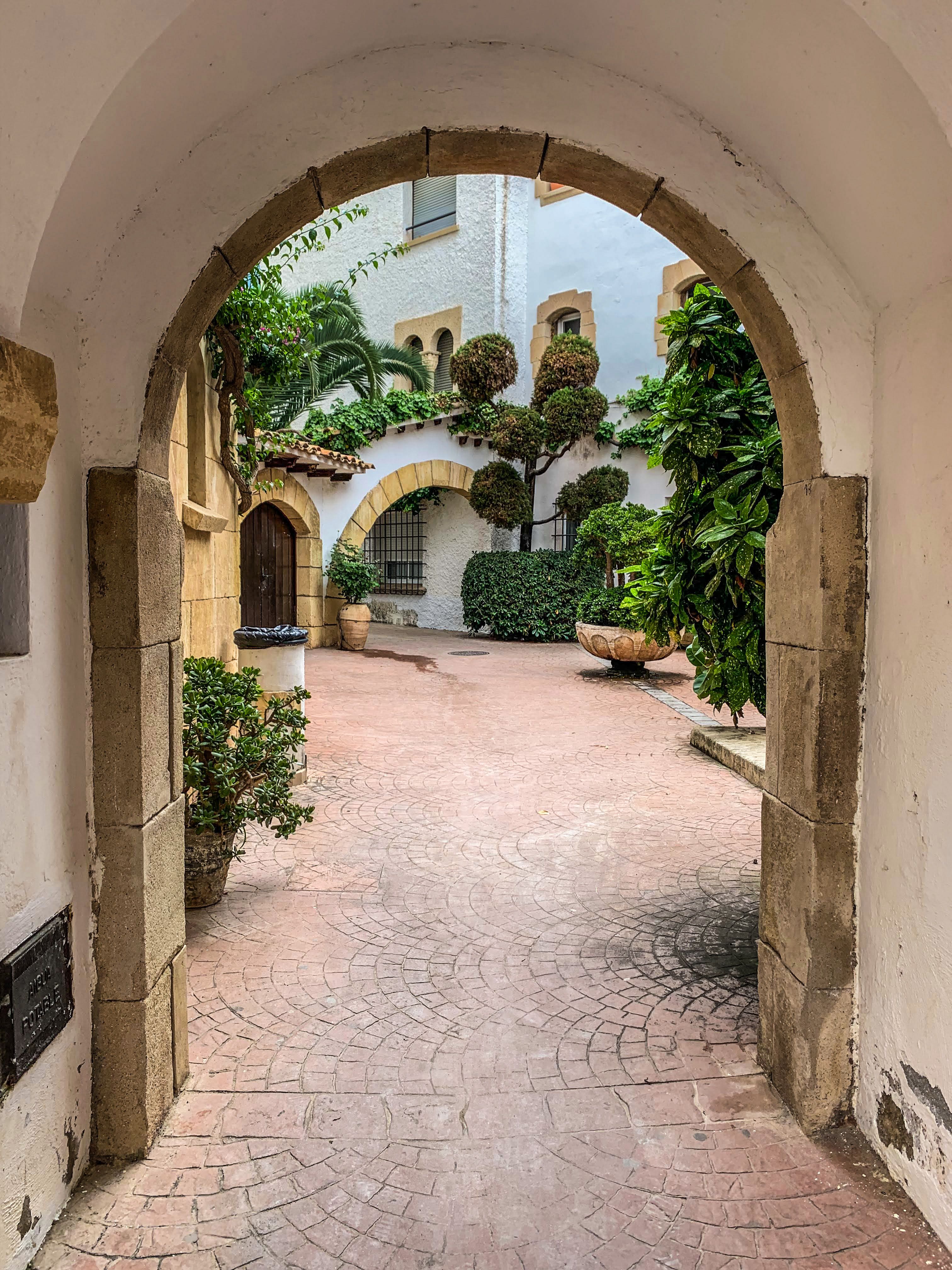 Charming Mediterranean Courtyard with Archway · Free Stock Photo