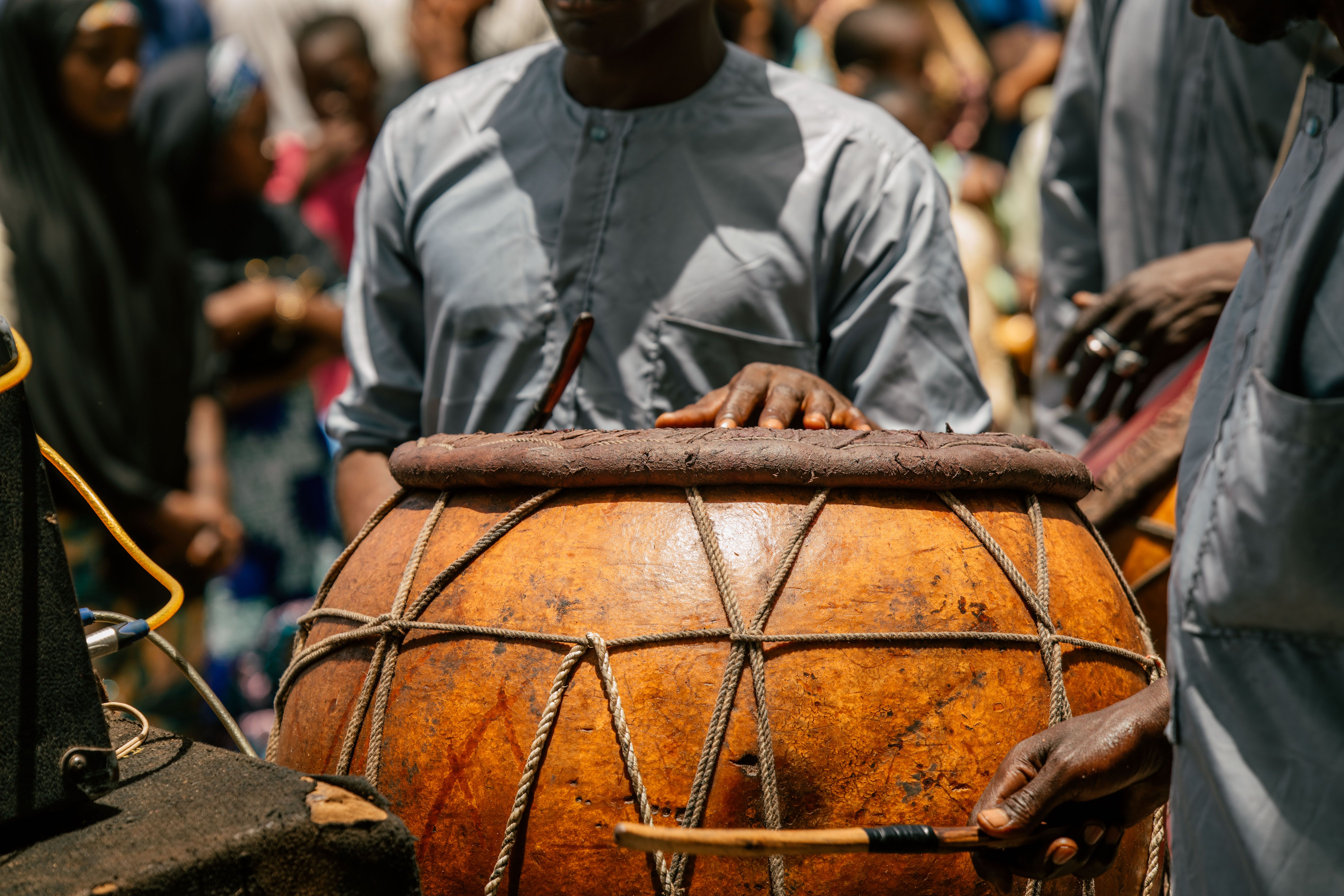 African drummers playing traditional instruments at an outdoor cultural gathering.