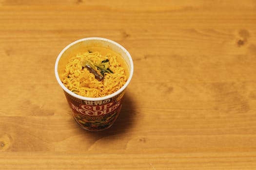 Close-up of a cup noodle on a wooden table, traditional Japanese fast food.