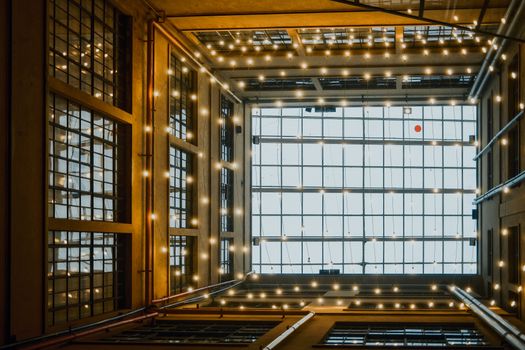 Captivating view of a lit atrium with geometric patterns and warm string lights in São Paulo.